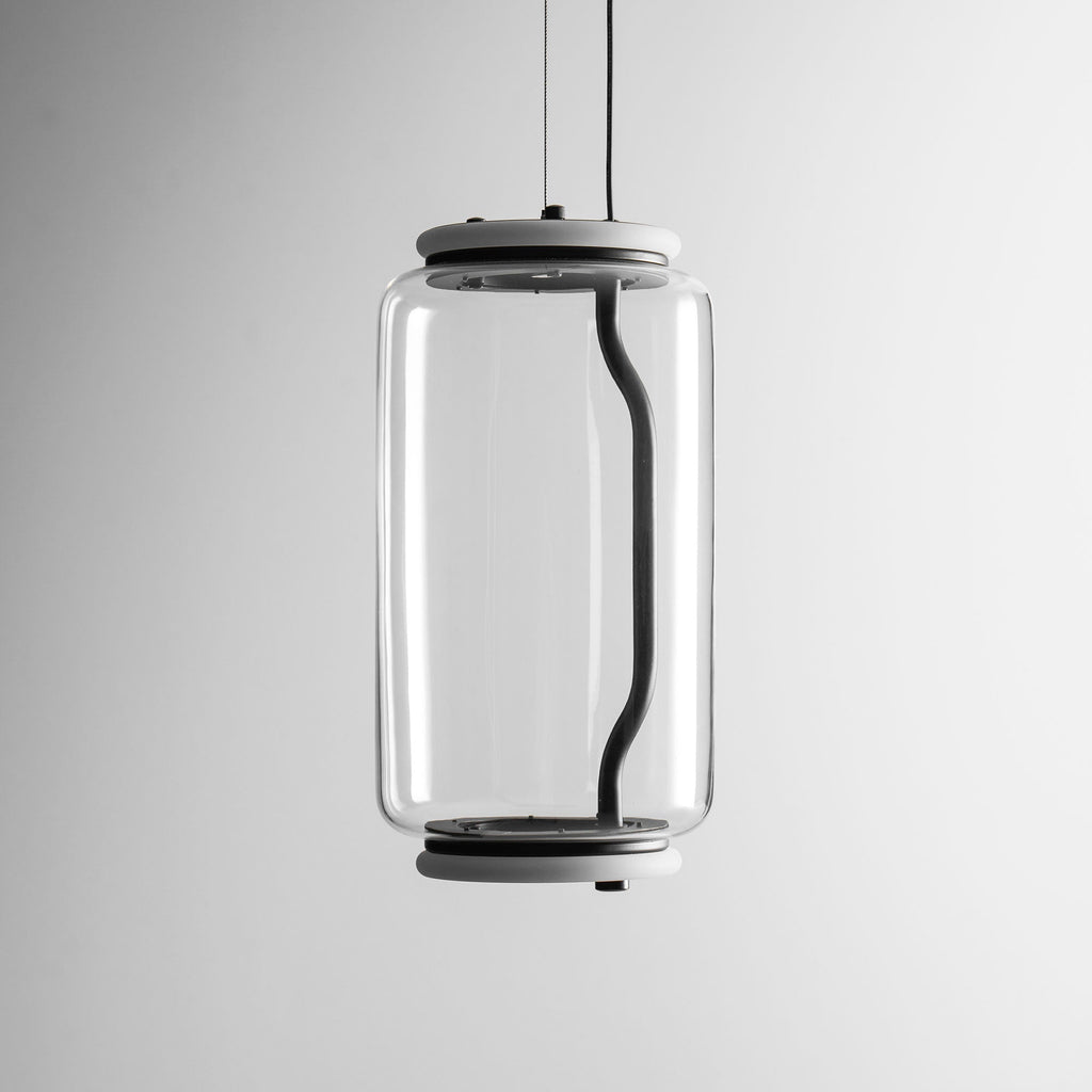 Close view of this Clérachic pendant's single glass cylinder, showing its black cord looping inside the glass.