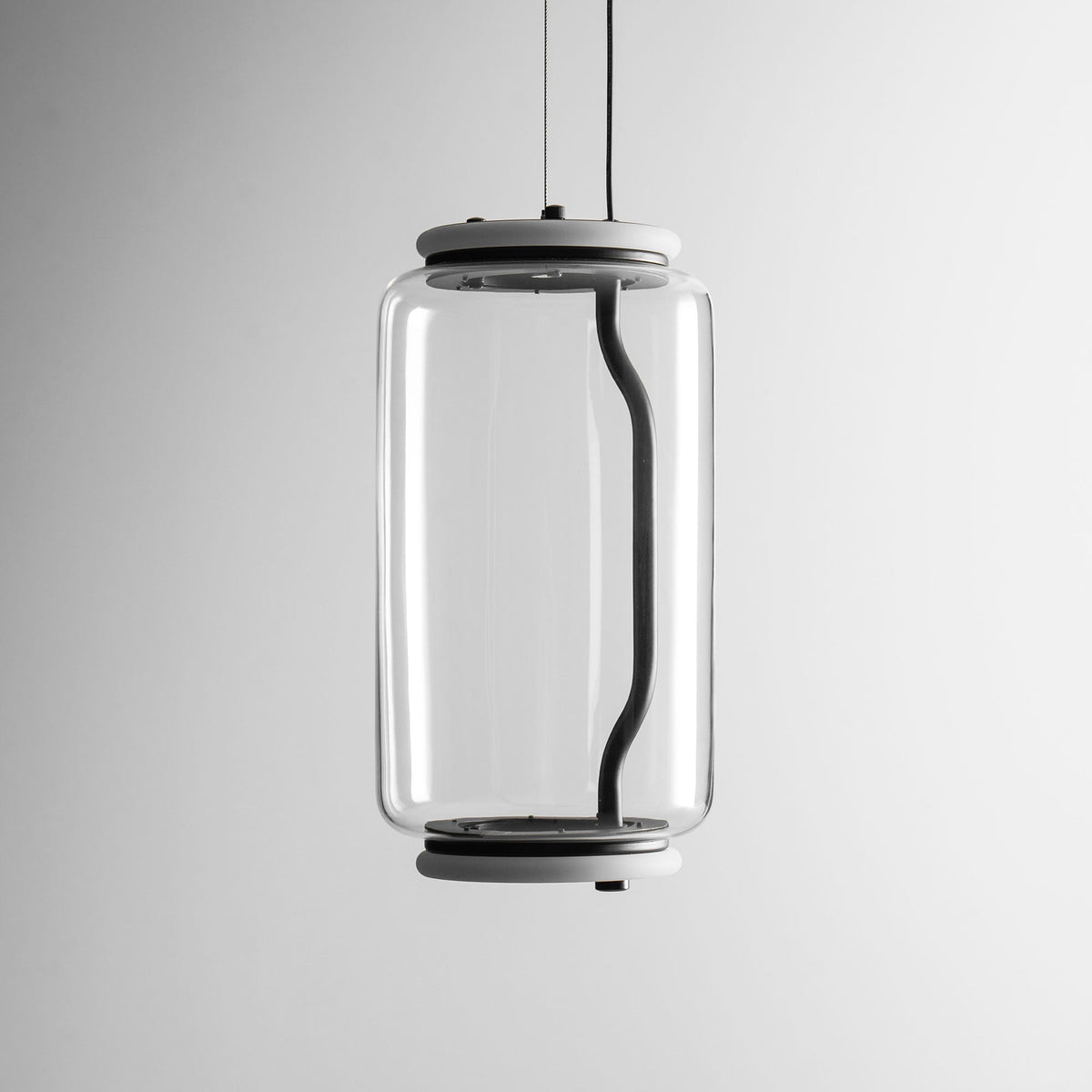 Close view of this Clérachic pendant's single glass cylinder, showing its black cord looping inside the glass.
