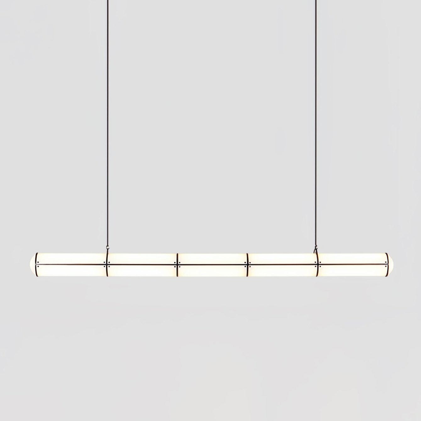 Linear pendant light in gold finish hanging in an interior