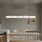 Linear pendant light glowing above a table in a warm interior
