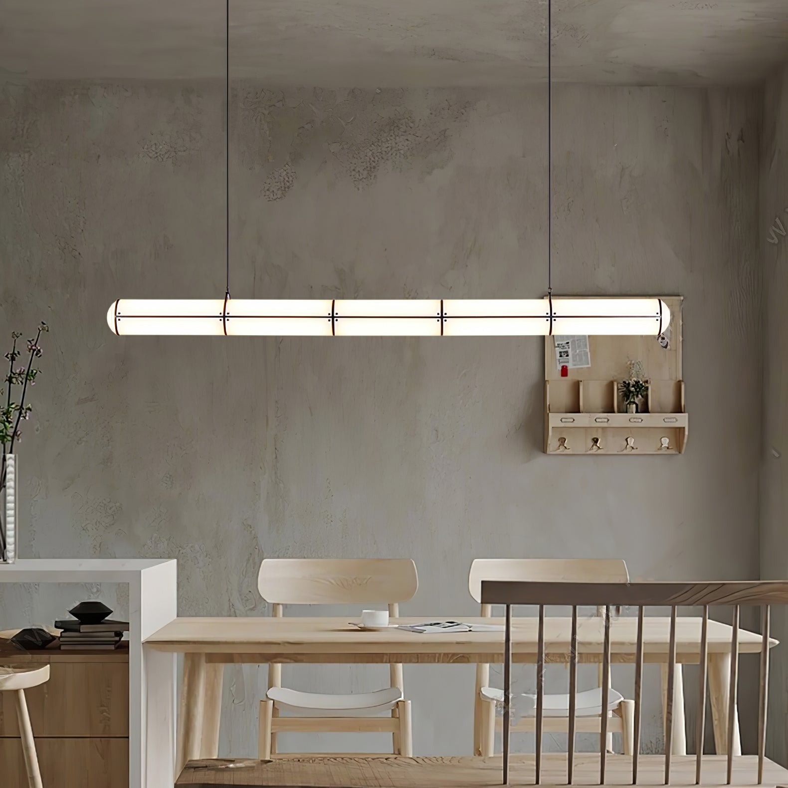 Linear pendant light glowing above a table in a warm interior