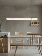 Linear pendant light shown lit in an evening interior