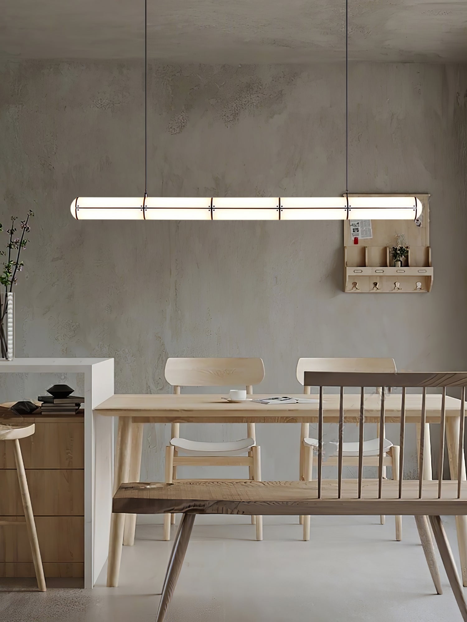 Linear pendant light shown lit in an evening interior