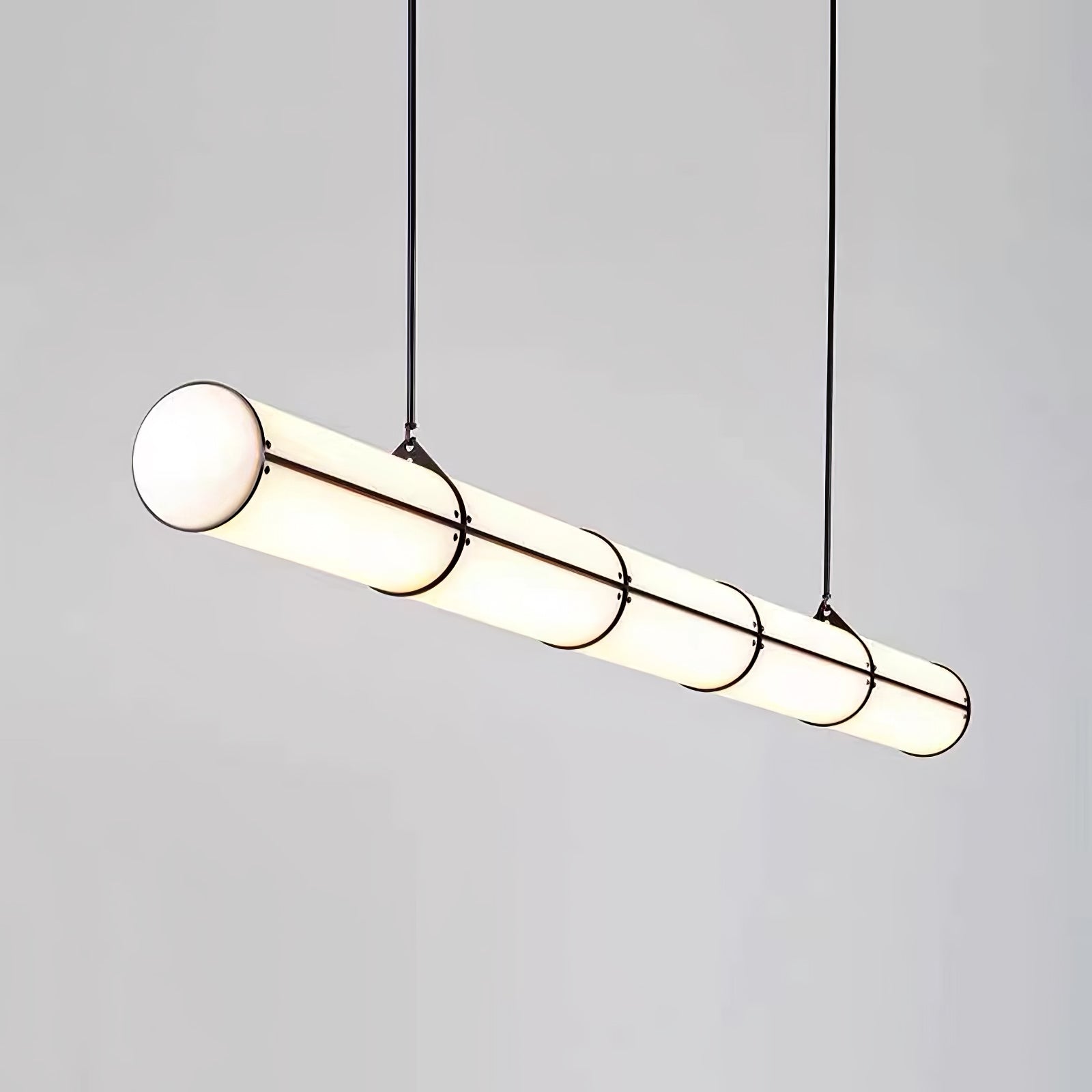 Linear pendant light suspended above a table in a styled space