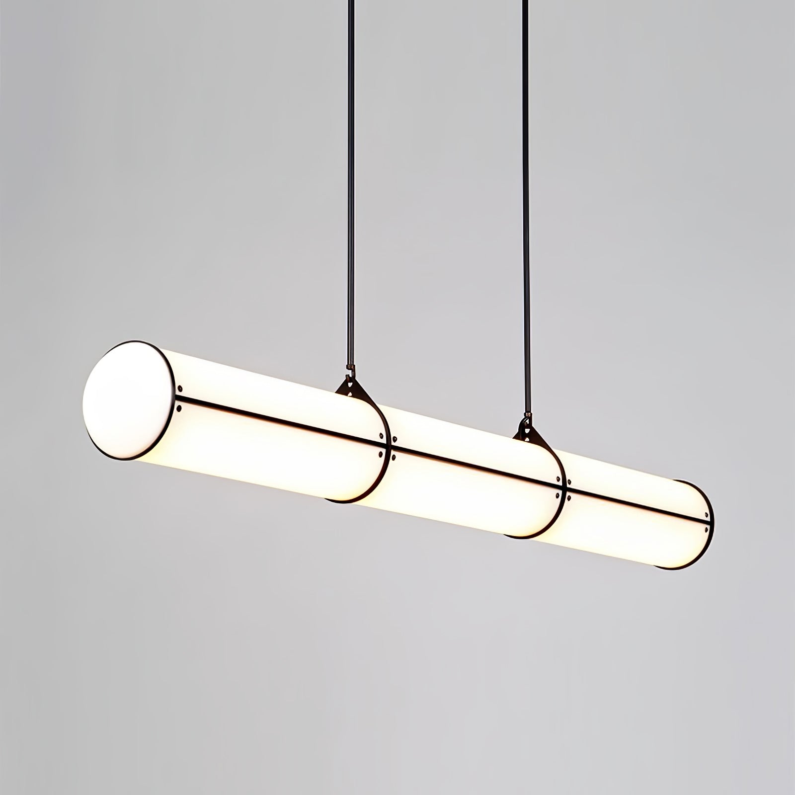 Linear pendant light glowing above a styled table
