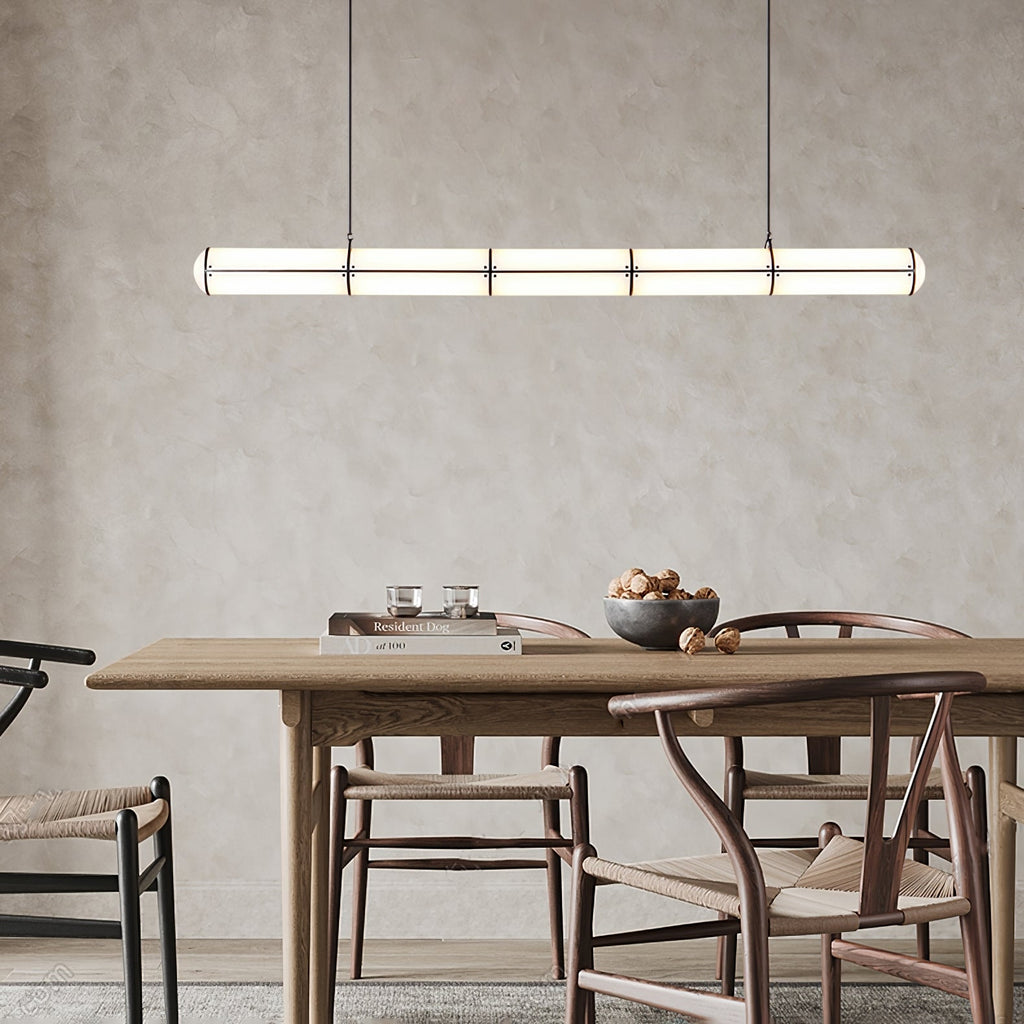Linear pendant light suspended over a styled dining space
