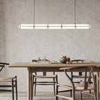 Linear pendant light suspended over a styled dining space
