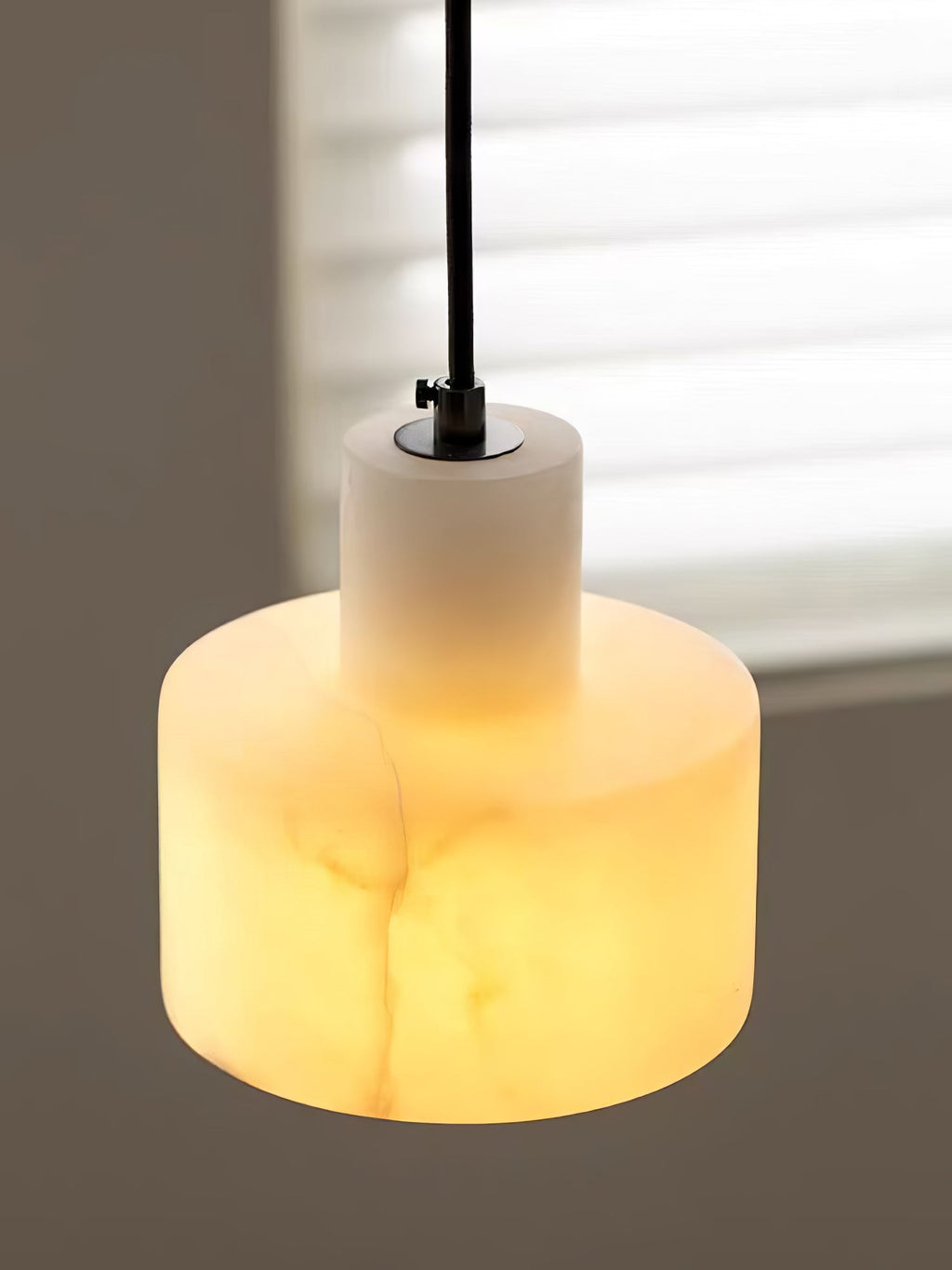 Alabaster pendant light suspended above a reading nook