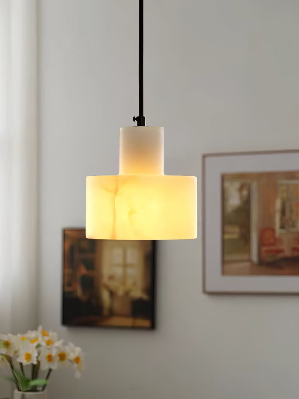Alabaster pendant light casting warm light over a side table