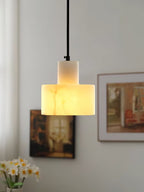 Alabaster pendant light casting warm light over a side table