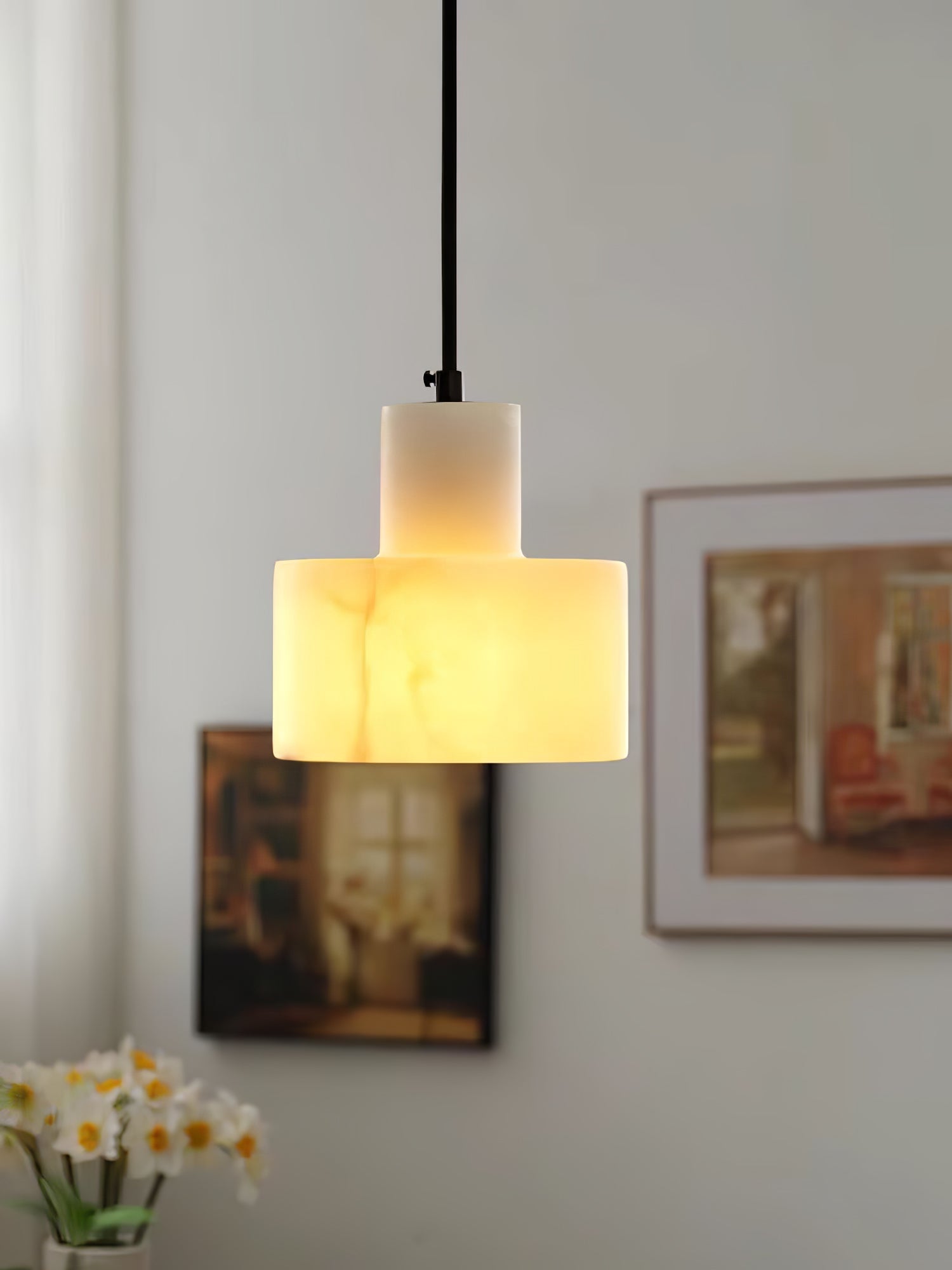 Alabaster pendant light casting warm light over a side table