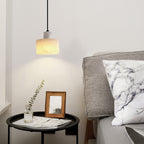Warm alabaster pendant light glowing in a dim room