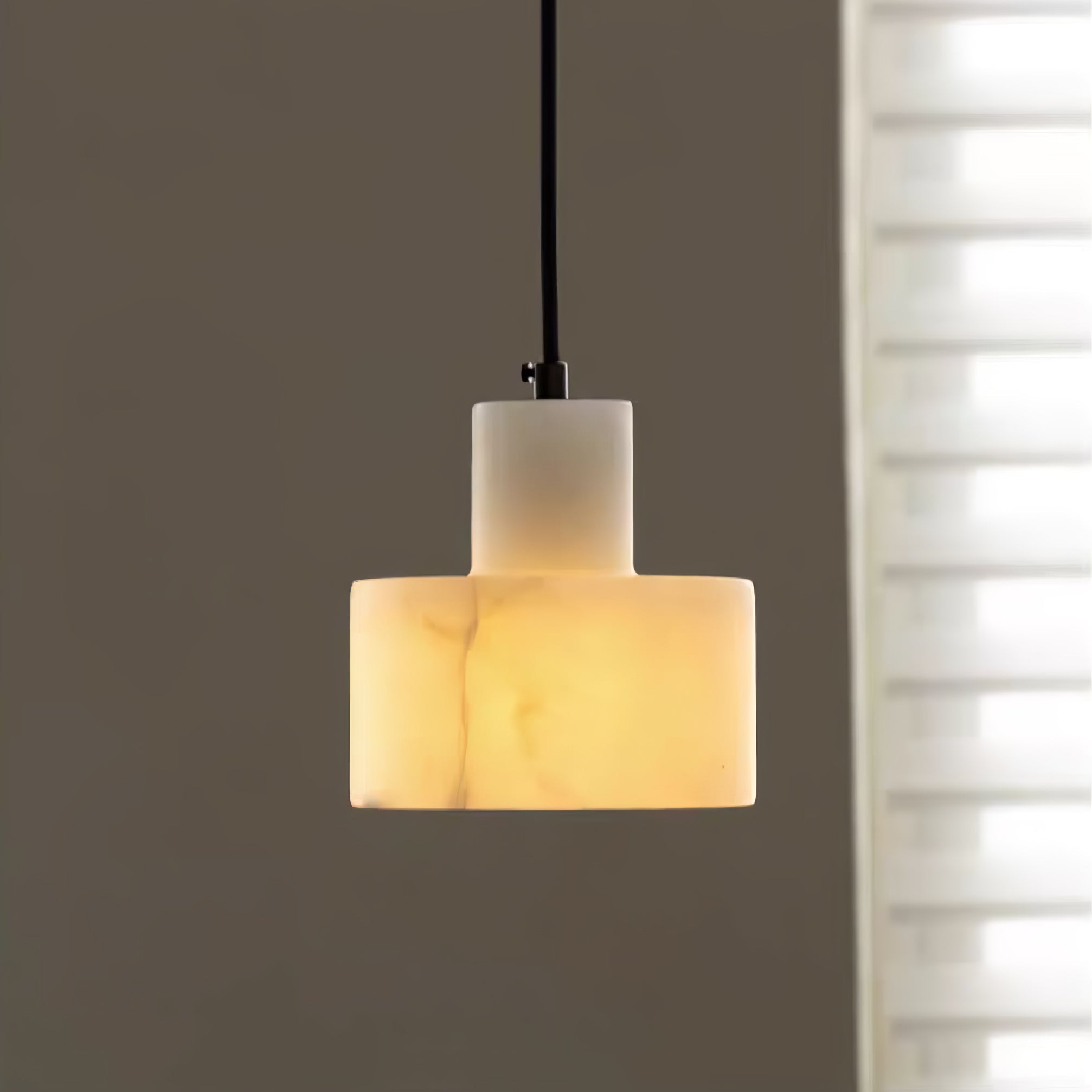 Alabaster pendant light hanging at the centre of a room