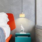 Alabaster pendant light lit warmly beside soft furnishings