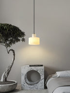 Alabaster pendant light glowing over a styled tabletop