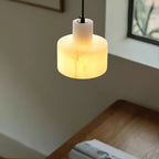 Two alabaster pendant lights grouped above a counter