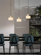 Small alabaster pendant light lit warmly in an interior