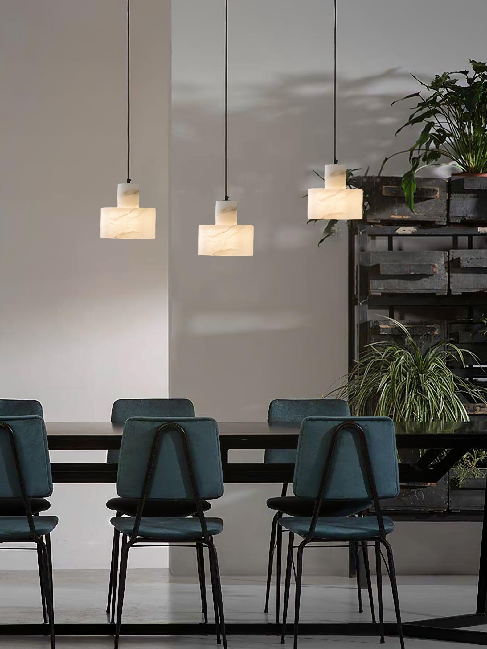 Small alabaster pendant light lit warmly in an interior
