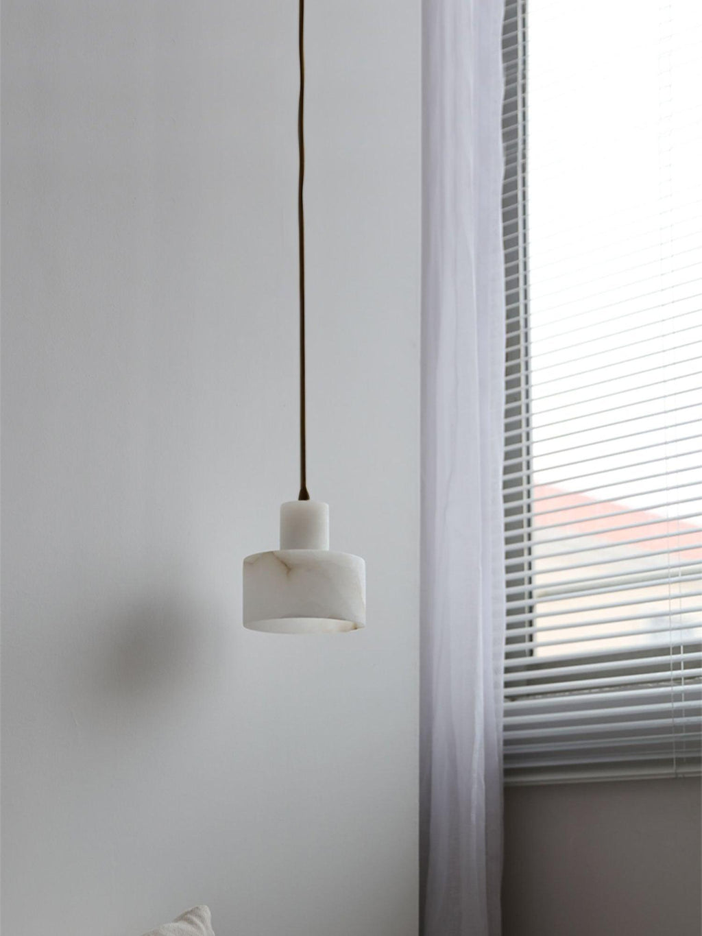 Large alabaster pendant light glowing in a styled room
