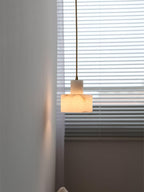 Alabaster pendant light shown beside a bedside table
