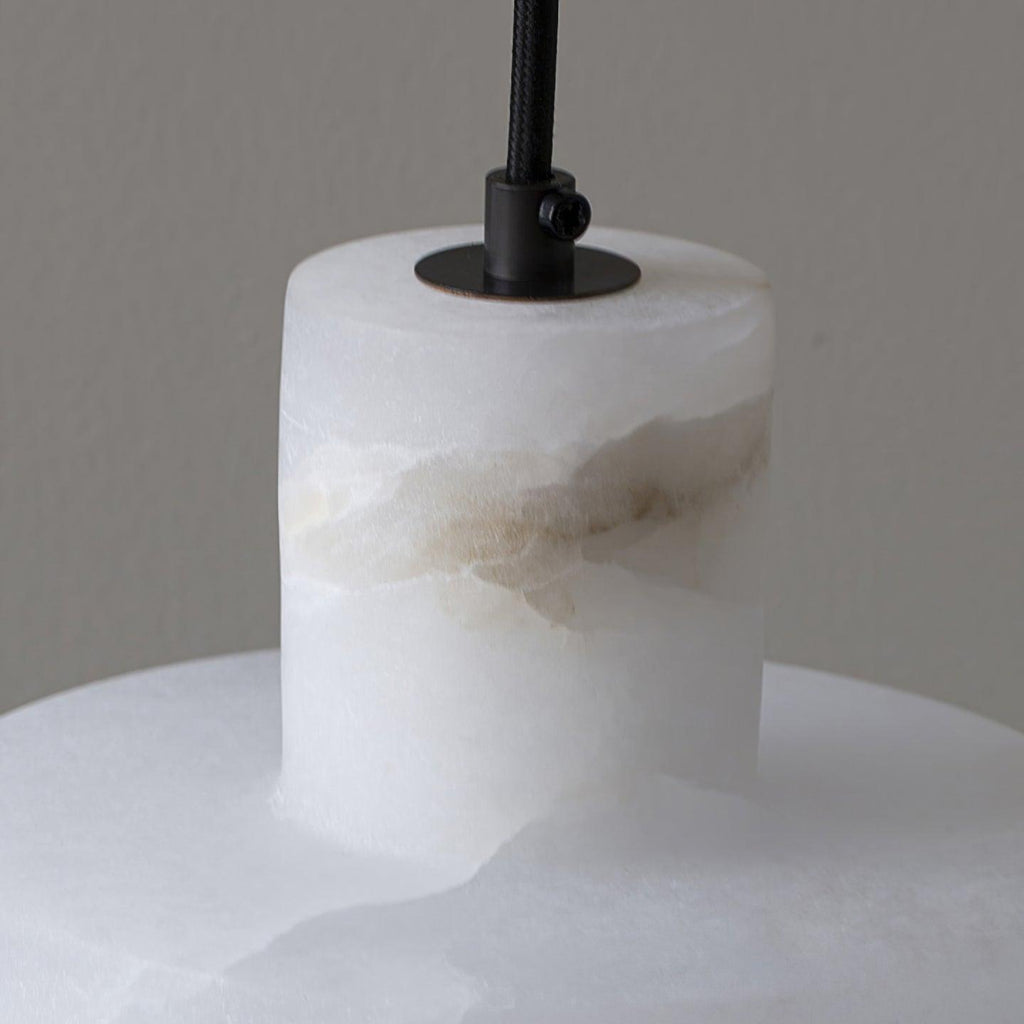 Alabaster pendant light lit, set against a neutral wall