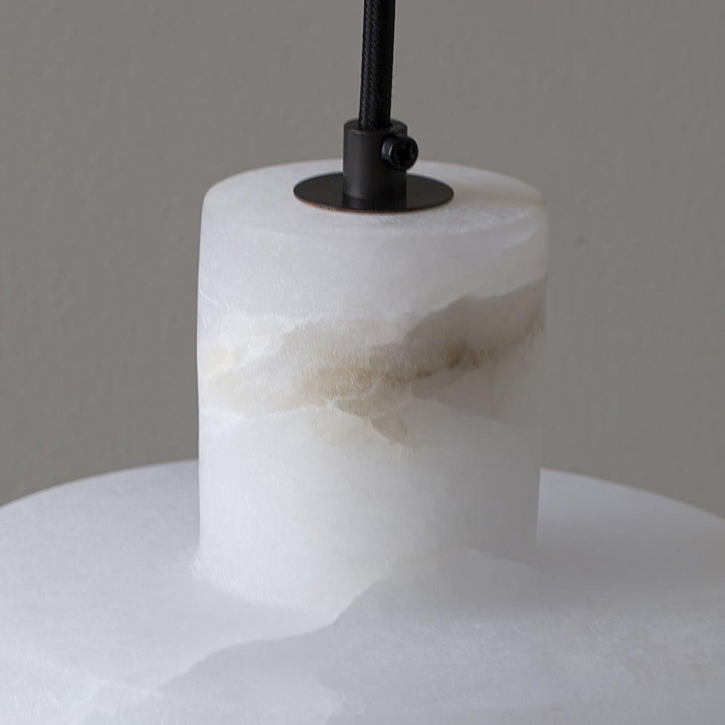 Alabaster pendant light lit, set against a neutral wall