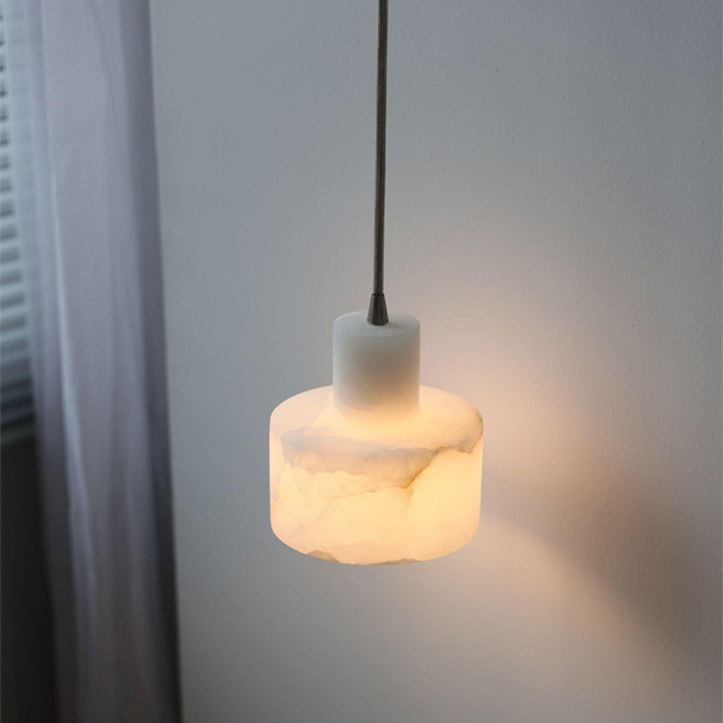 Alabaster pendant light glowing over a dining table