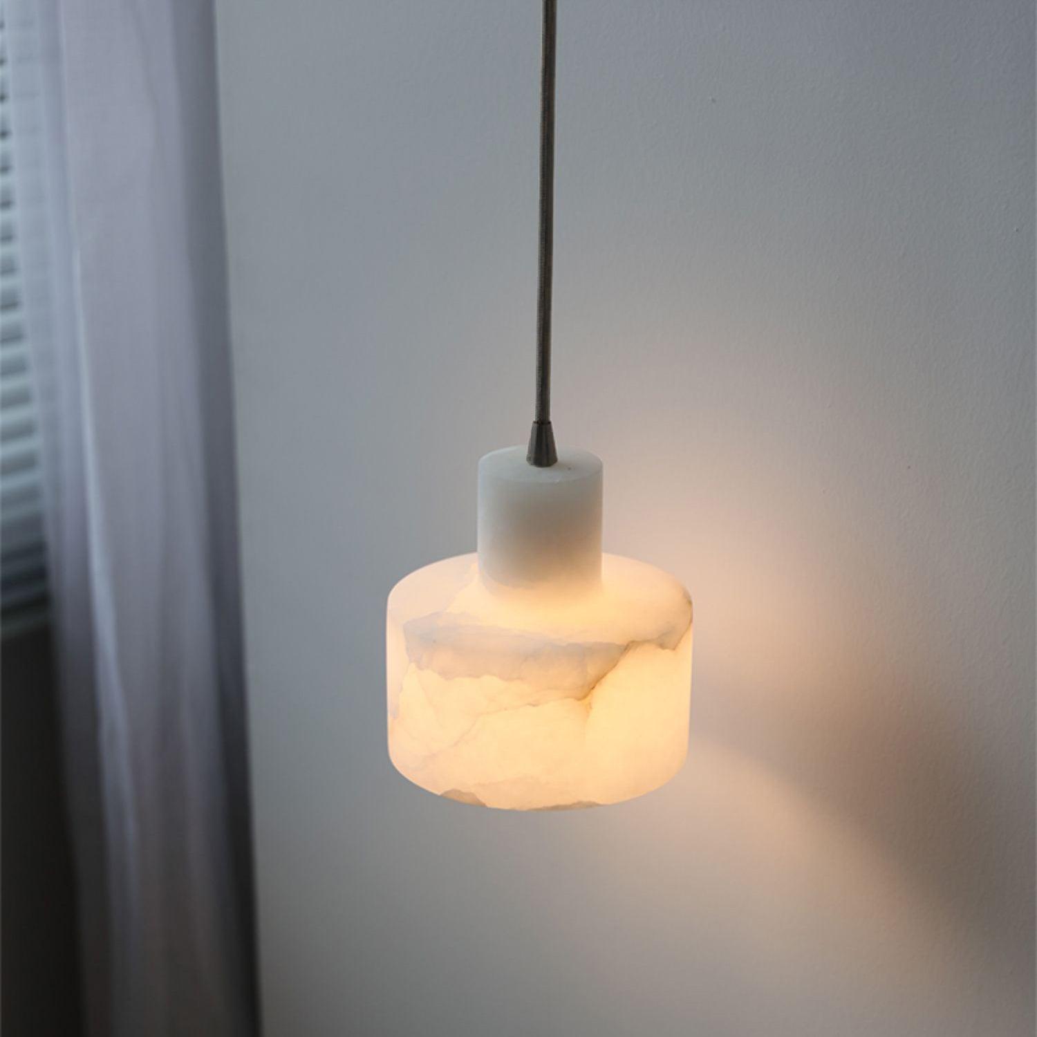 Alabaster pendant light glowing over a dining table