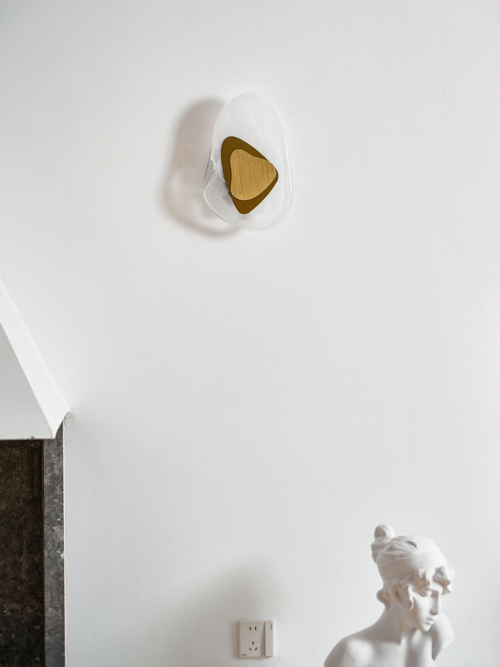 Black translucent glass wall lamp lit on a dark feature wall