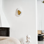 Wall lamp with glowing shade shown in a cosy interior