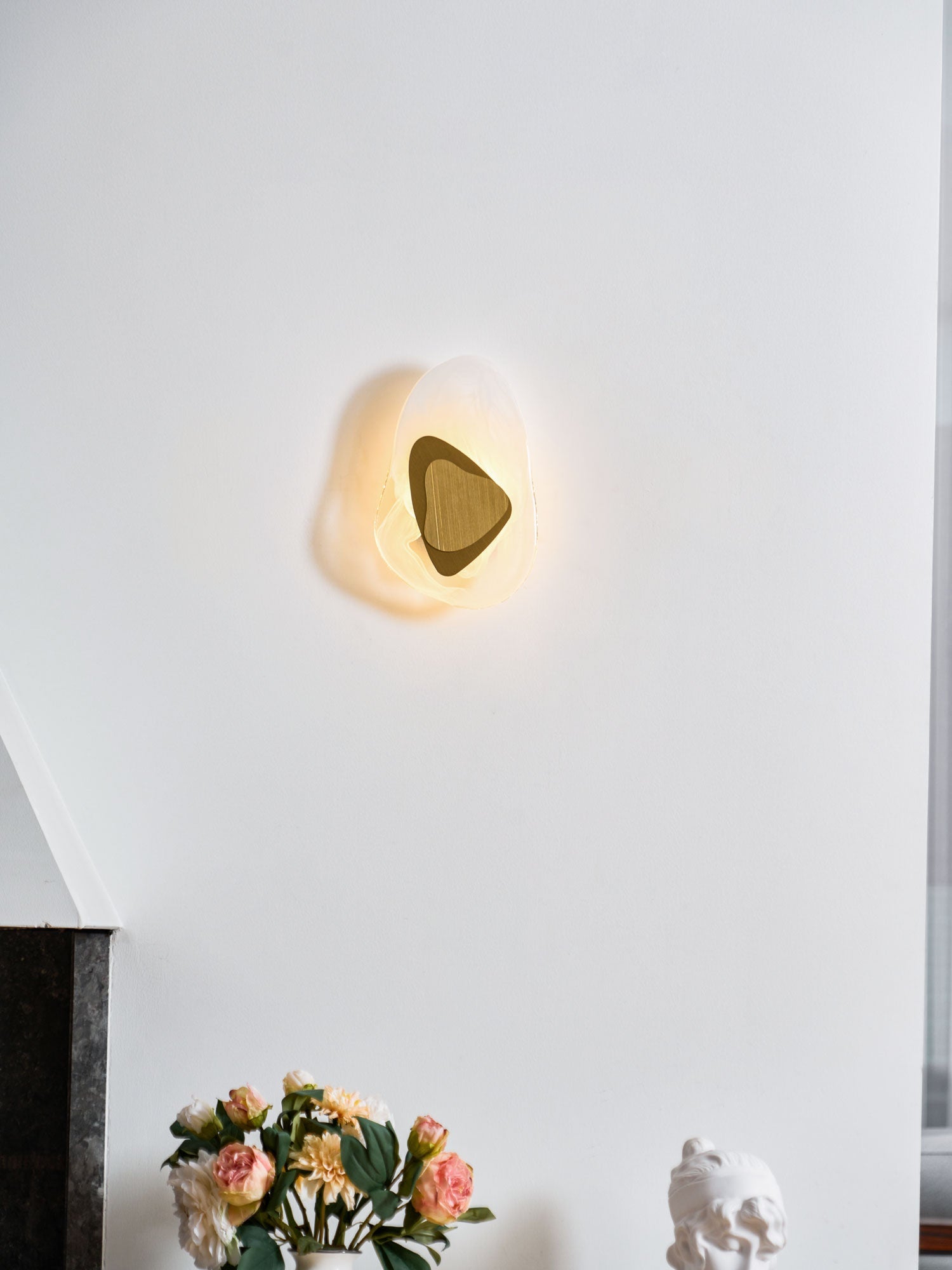 Copper wall lamp lit as an accent in a styled living space