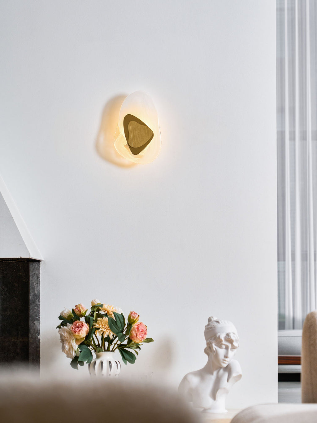 Wall lamp with translucent shade lighting a bedside wall