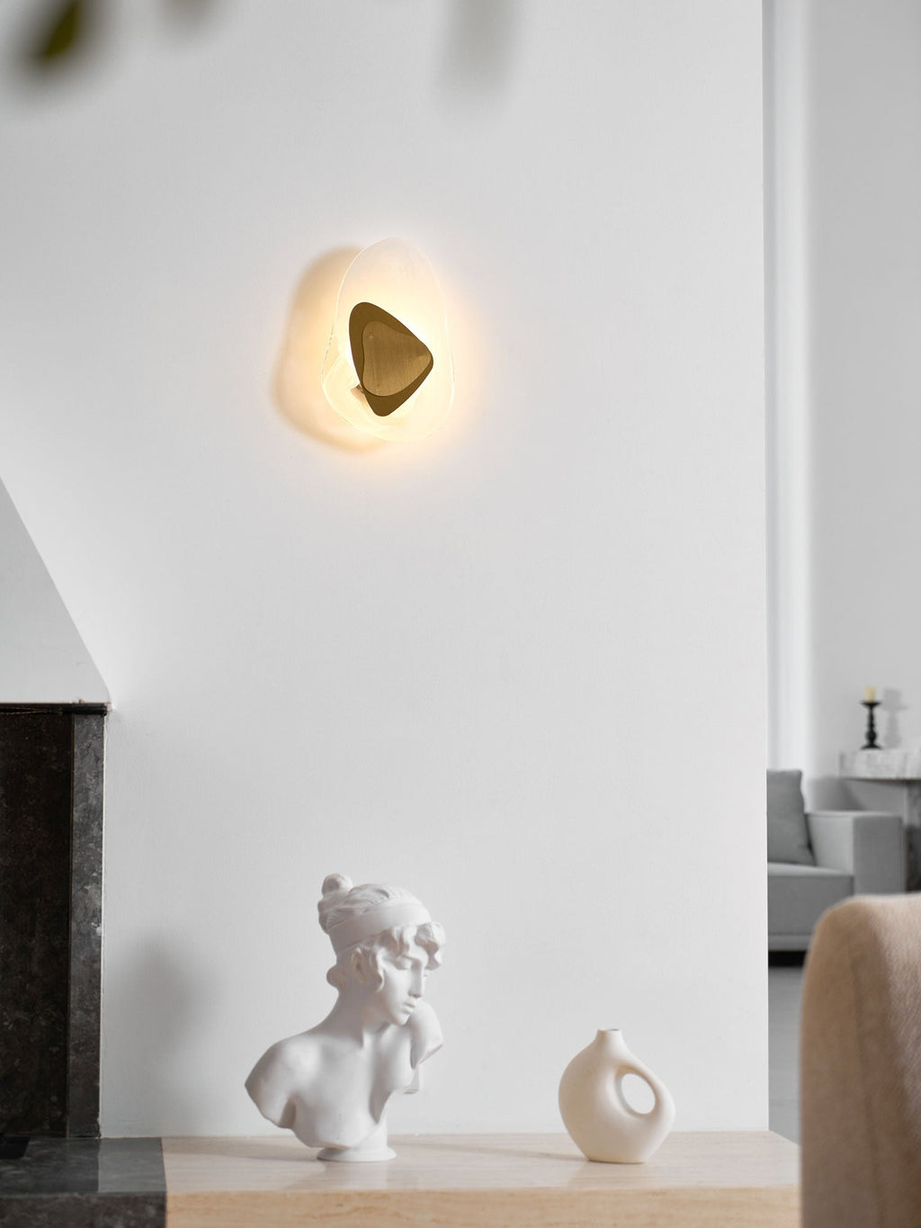 Wall lamp with translucent glass shade shown in profile