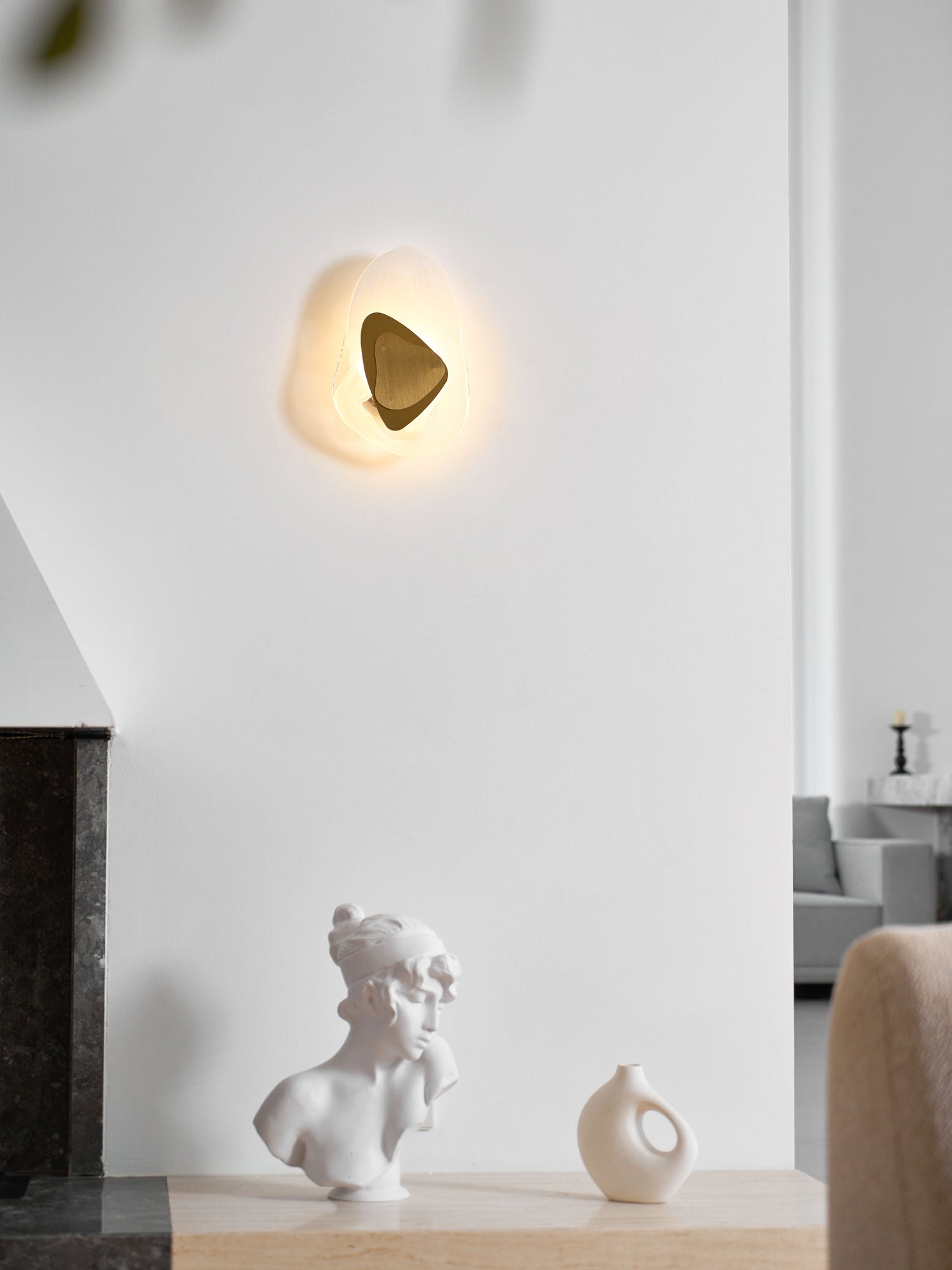 Wall lamp with translucent glass shade shown in profile
