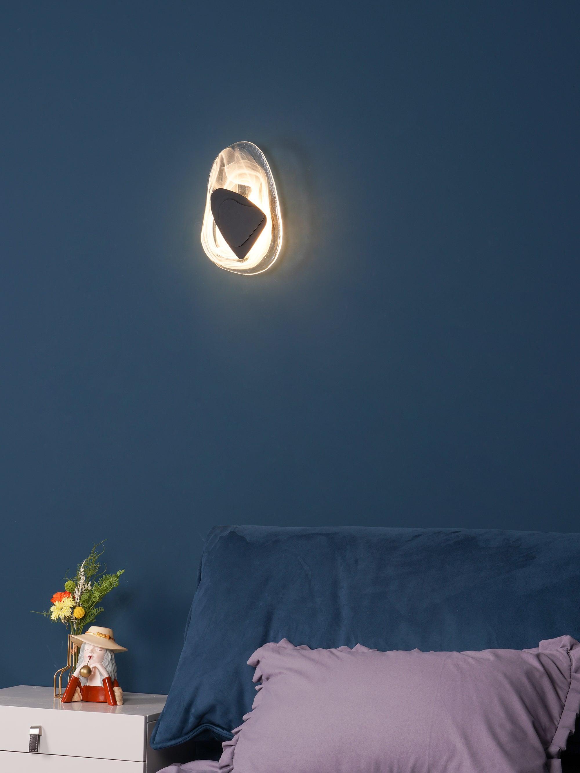 Translucent glass wall lamp glowing beside a seating area
