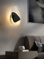 Black wall lamp lit softly against a pale wall