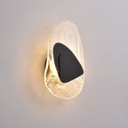 Translucent glass wall lamp glowing softly against a dark wall