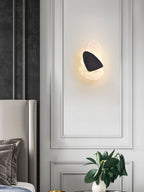 Copper wall lamp lit softly beside a staircase