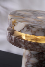 Macro crop of the Clérachic lamp's disc gap, the LED glow lighting the veined marble from underneath at an angle.