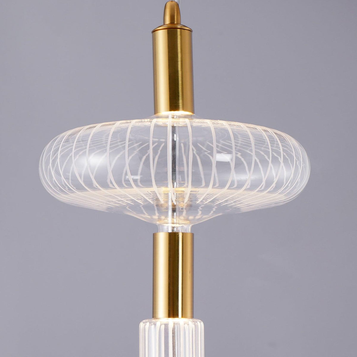 Close view of an angular ribbed glass shade catching light on this Clérachic pendant.