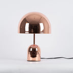 A straight-on product view of this Clérachic table lamp in rose gold against a soft grey background.