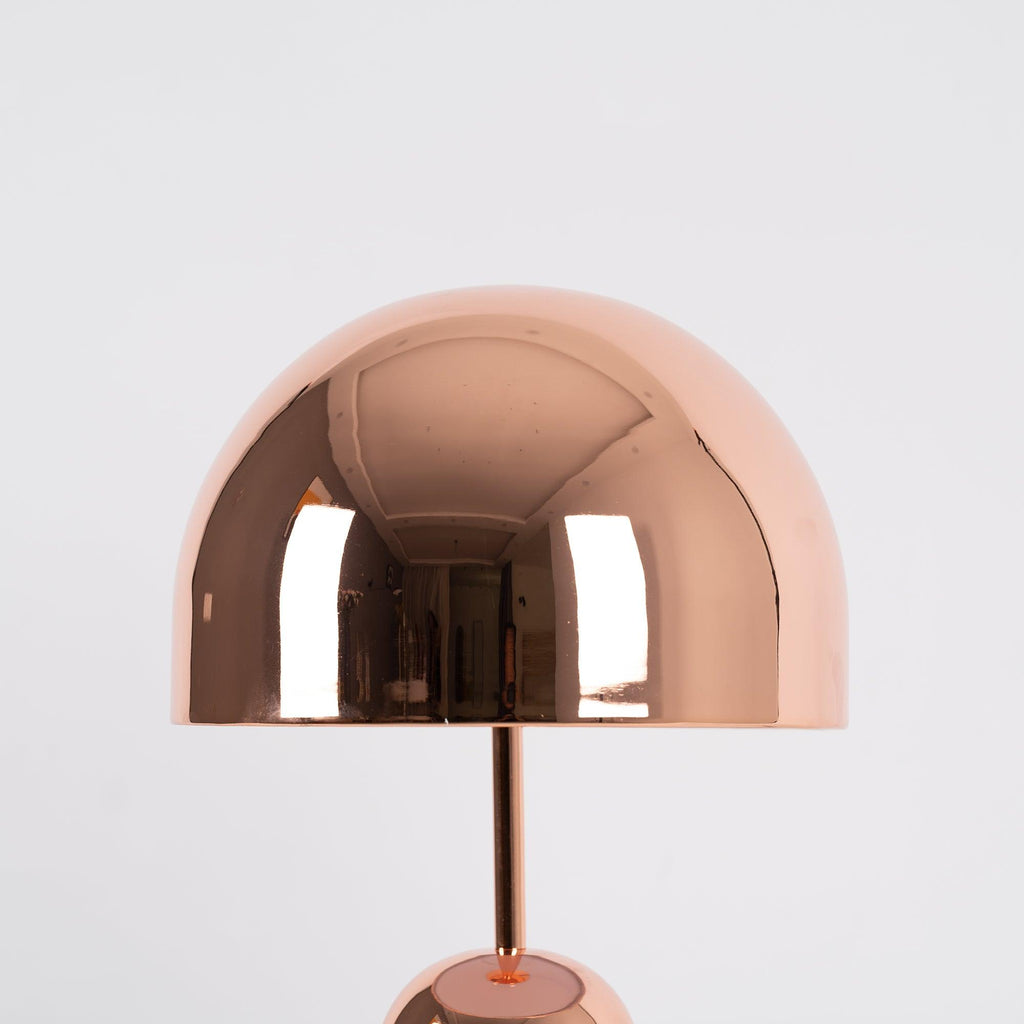 A low-angle view shows the dome shade of this Clérachic rose gold table lamp filling most of the frame.