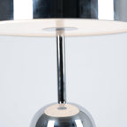 Looking up into the dome shade of this Clérachic chrome table lamp reveals the stem and a white diffuser disc.