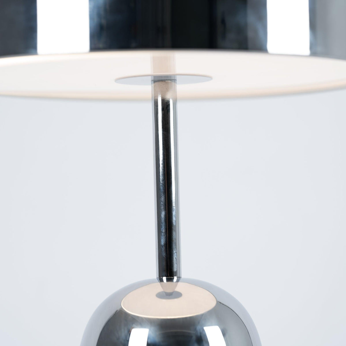Looking up into the dome shade of this Clérachic chrome table lamp reveals the stem and a white diffuser disc.