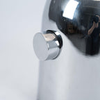 A macro shot of the round push-button switch set into the chrome base of this Clérachic table lamp.