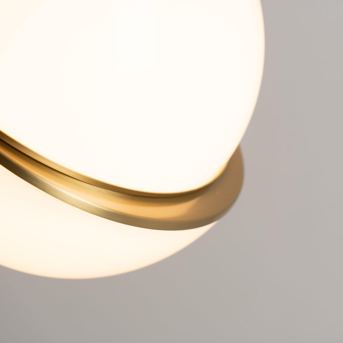 Close view of the brass band crossing this Clérachic pendant's opal sphere, seen from below.