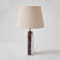 The Clérachic marble table lamp turned to a side profile, cord dropping from the base on a plain studio backdrop.