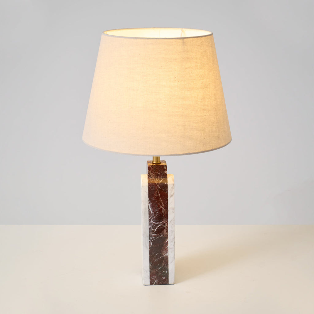 A close view from below the lit shade of the Clérachic table lamp, its warm interior bright against the base.