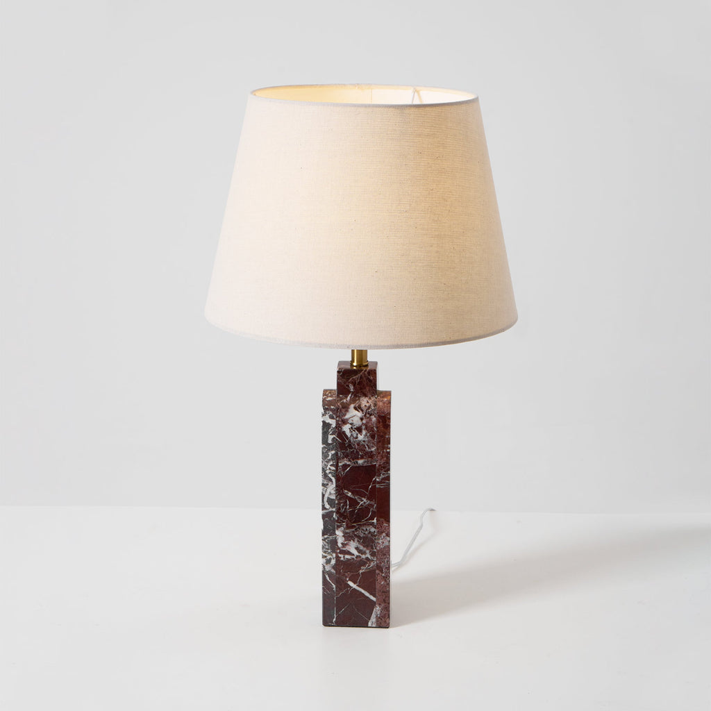 The Clérachic marble table lamp turned slightly left on a studio background, cord trailing from its base.
