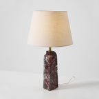 A Clérachic marble table lamp faces forward on a plain studio background, its beige shade unlit above the stone column.